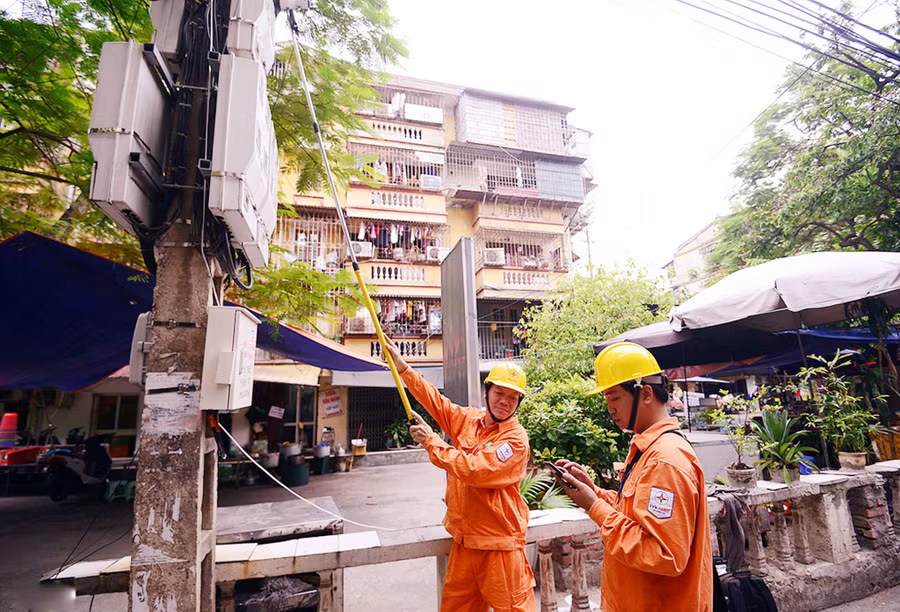 Công nhân ngành điện sử dụng công nghệ trong việc ghi số điện tiêu thụ dân dụng
