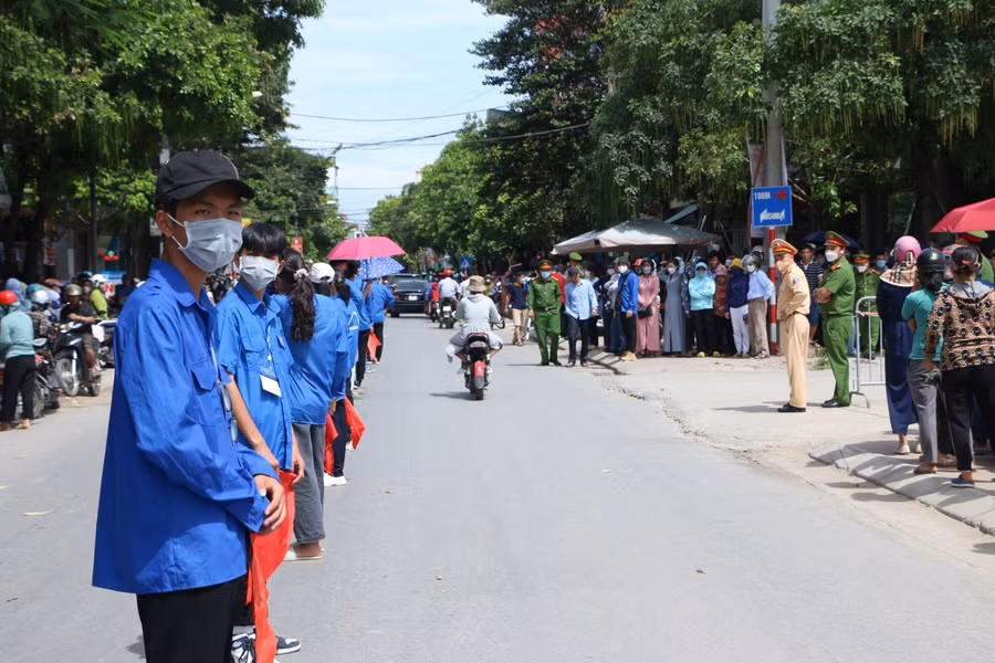 Lực lượng thanh niên tình nguyện phối hợp với Công an huyện phân luồng, đảm bảo giao thông tại cổng trường thi.