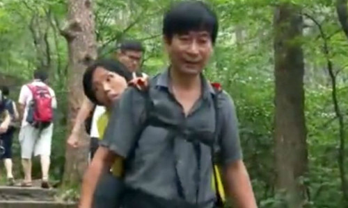 AnhWang Xiaomin địu vợ leo núi. AnhWang Xiaomin địu vợ leo núi. Ảnh:Yahoo News Singapore.