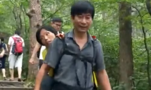 AnhWang Xiaomin địu vợ leo núi. Ảnh:Yahoo News Singapore.