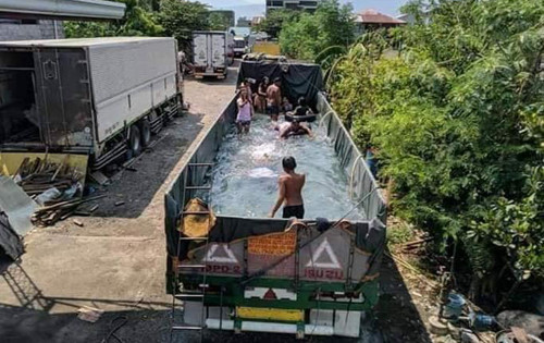 Vợ con muốn đi biển, tài xế chế xe tải thành bể bơi cực sáng tạo ảnh 3 Cả nhà vui vẻ tắm trên thùng xe.