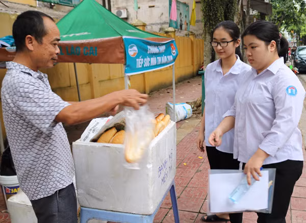 Người dân ở huyện Bảo Thắng tự nguyện phát bánh mì miễn phí cho thí sinh.