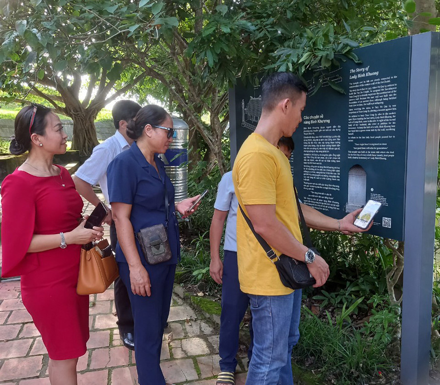 Du khách quét mã QR khi tham quan tại đền thờ nàng Bình Khương. (Ảnh: Triệu Hương)