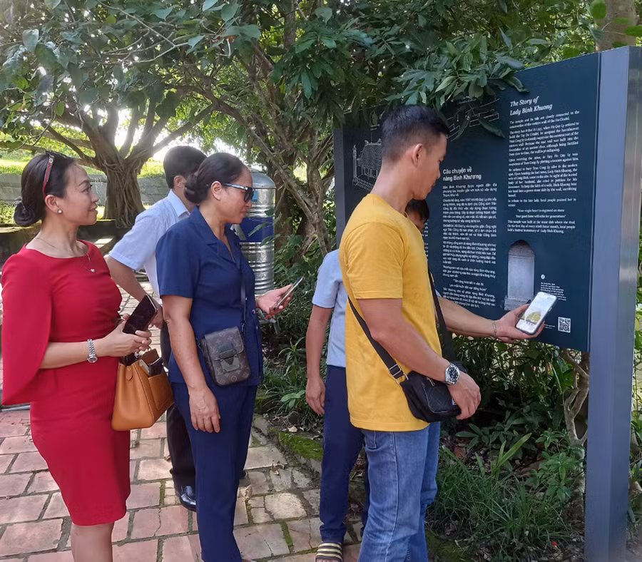 Du khách quét mã QR khi tham quan tại đền thờ nàng Bình Khương. (Ảnh: Triệu Hương)
