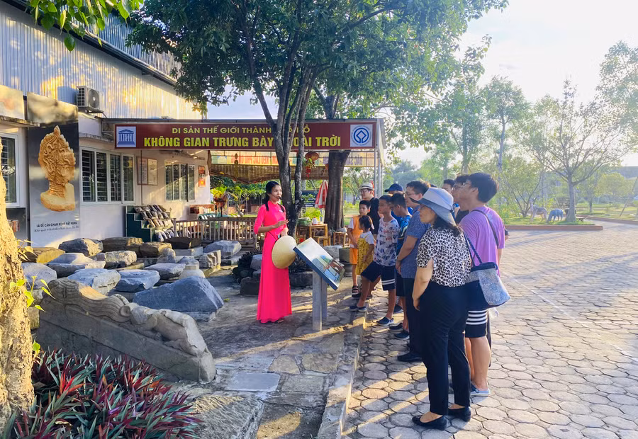 Du khách được hướng dẫn viên giới thiệu về khu trưng bày hiện vật ngoài trời tại di sản Thành nhà Hồ.