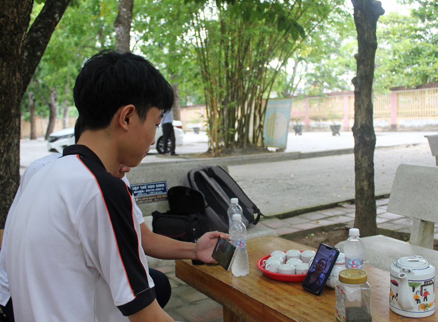 Quang trò chuyện với mẹ qua điện thoại. Ảnh: LT. Quang trò chuyện với mẹ qua điện thoại. Ảnh: LT.