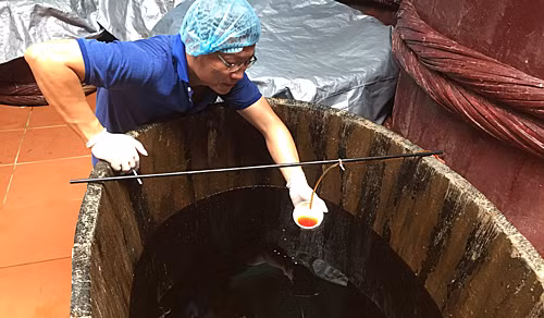 Nước mắm cốt truyền thống nhỉ ra từ thùng gỗ vàcó màu hổ phách.Ảnh: Lê Gia.