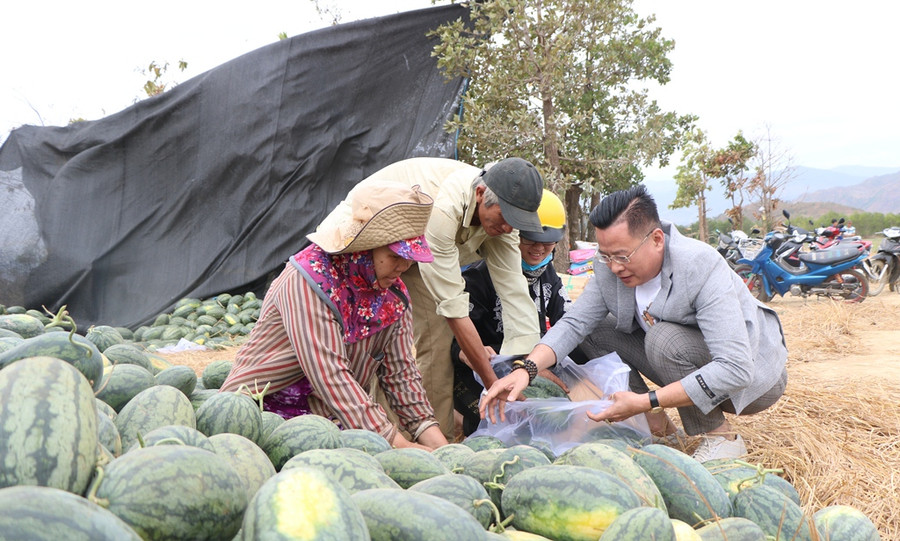 Ông Nguyễn Thanh Hồng (phải) mua dưa ủng hộ bà con nông dân. (Ảnh: Ý Thảo).