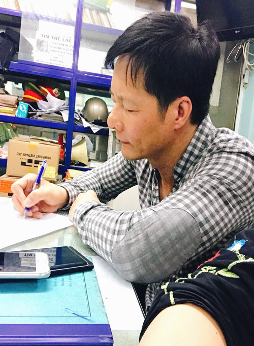 Ông Nguyễn Đức An viết trình báo tại công an. Ảnh:Phan Thảo Ông An viết trình báo tại công an. Ảnh; Phan Thảo