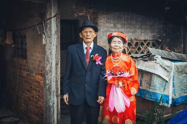 Lễ cưới được tổ chức tại hội trường ủy ban phường Quỳnh Dị (Hoàng Mai, Nghệ An) trong sự chứng kiến của gia đình, bà con hàng xóm. Tình cờ nhận chạy xe hoa cho hai cụ từ nhà lên hội trường, anh Hồ Đức Việt đã may mắn ghi lại khoảnh khắc hạnh phúc của hai cụ.