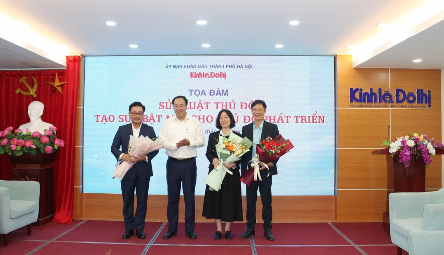 Ban tổ chức tặng hoa các diễn giả tham gia toạ đàm “Sửa Luật Thủ đô: Tạo sức bật mới cho Thủ đô phát triển”. (Ảnh: Công Phương)