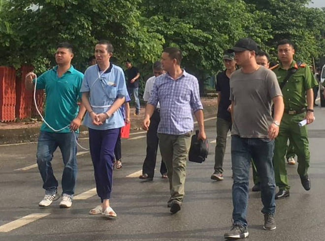 Cảnh sát dẫn giải Bùi Văn Công đến hiện trường. Ảnh: Đại Việt. Ke siet co nu sinh giao ga duoc dua den thuc nghiem hien truong hinh anh 1