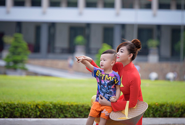 Thiếu nữ mặc áo dài cờ đỏ sao vàng thăm Dinh Độc Lập ảnh 7 Một em nhỏ ghé thăm Dinh Độc Lập cũng muốn được chụp ảnh cùng với cô gái mặc áo dài cờ đỏ sao vàng