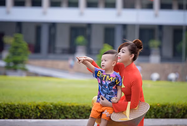 Một em nhỏ ghé thăm Dinh Độc Lập cũng muốn được chụp ảnh cùng với cô gái mặc áo dài cờ đỏ sao vàng