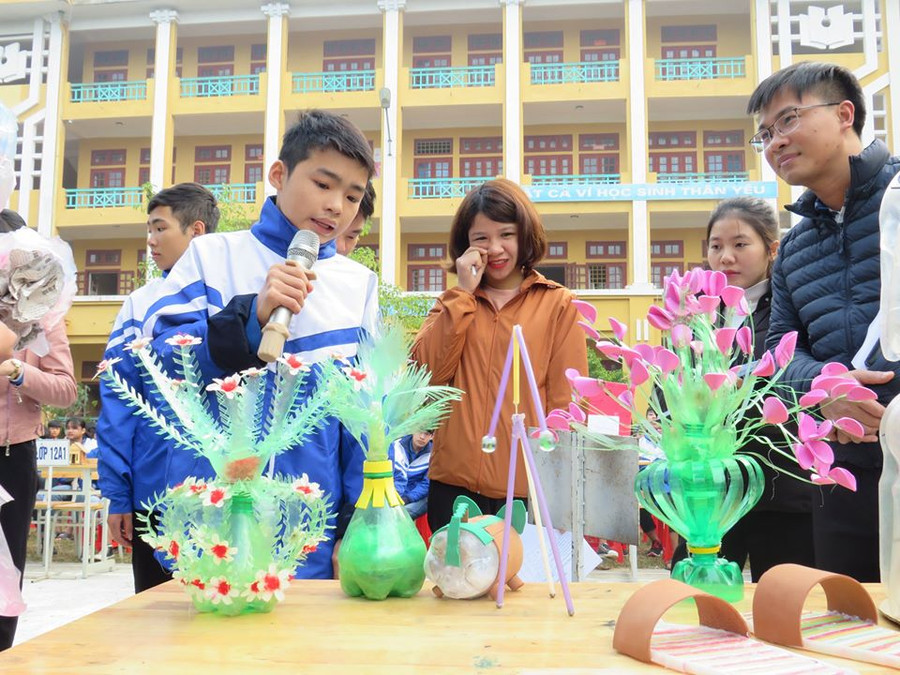 Em học sinh Hoàng Văn Miền (dân tộc Tày, cầm mic) thuyết trình về sản phẩm chế tác từ rác thải nhựa của lớp 11A1. Ảnh: T.G