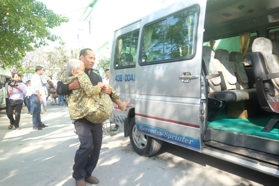 Các nhân viên bệnh viện Đà Nẵng đang hỗ trợ đưa bệnh nhân lên xe để về quê đón Tết cùng gia đình