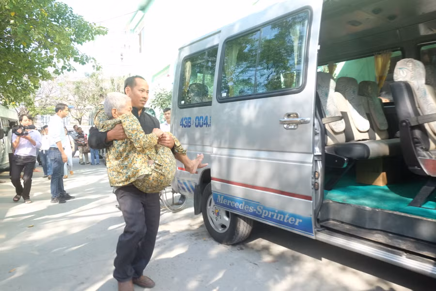 Các nhân viên bệnh viện Đà Nẵng đang hỗ trợ đưa bệnh nhân lên xe để về quê đón Tết cùng gia đình