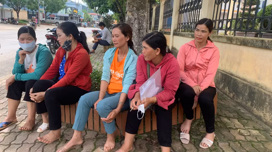 Chị Điêu Thị Luyến (áo cam ngồi giữa) cùng những bà mẹ thấp thỏm đợi con ngoài phòng thi.