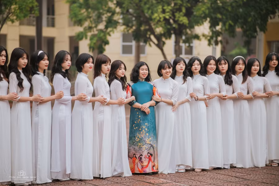 Cô giáo Đỗ Thị Chí (áo dài xanh đứng giữa) chụp ảnh kỷ yếu cùng học trò.