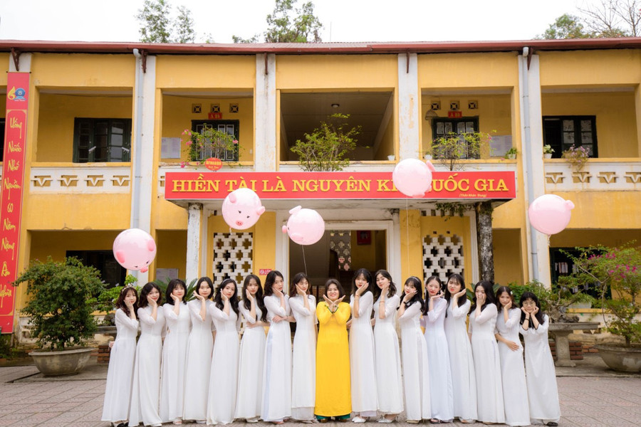 Cô Hoa (áo vàng, đứng giữa) chụp ảnh lưu niệm cùng học sinh. Cô Hoa (áo vàng, đứng giữa) chụp ảnh lưu niệm cùng học sinh.