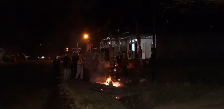 Nhóm thanh niên tập trung quanh đống lửa đón chờ thời khắc chuyển giao giữa năm cũ và năm mới.