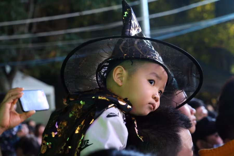 "Pphù thủy nhí” được bố mẹ cõng trên lưng đi dự Halloween.