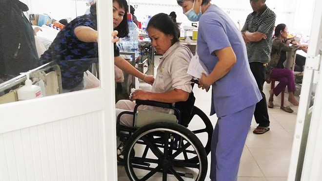 Hơn một ngày sau khi cấp cứu, bà Hương vẫn phải di chuyển bằng xe lăn. Ảnh: Q.H. Tai xe oto noi ve ly do tong nguoi sau au da tai chung cu Gold View hinh anh 2