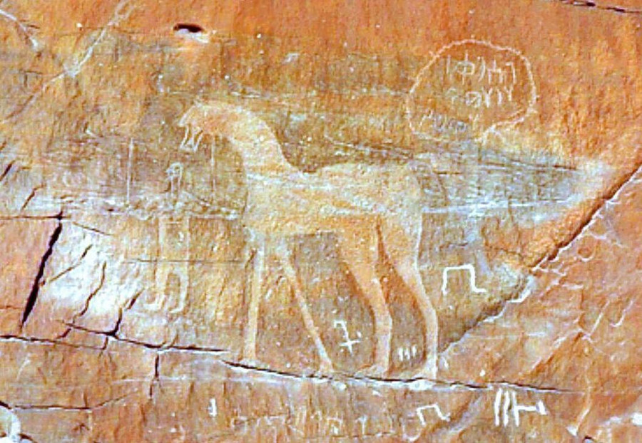 Mặt trước khối đá phẳng có những hình vẽ, ký tự kỳ lạ, bí ẩn. Đây có thể là những ghi chép, bút tích của người tối cổ về ốc đảo Tayma từ thế kỷ 8 trước Công nguyên. Mặc dù sự hình thành vết cắt và ý nghĩa của hình vẽ trên bề mặt còn là bí ẩn lớn, khối đá Al Naslaa vẫn thu hút hàng nghìn du khách đến với vùng đất Tayma hàng năm. Ảnh: Indocropcircles.wordpress. Vet cat bi an chia doi khoi da van nam tuoi o Arab Saudi hinh anh 7