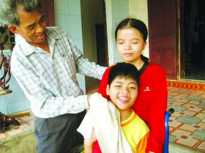 Ông Địu lau mặt cho hai con gái tật nguyền Đỗ Thị Hằng và Đỗ Thị Nga. Trong ba đứa con sống sót, chỉ cô con gái thứ hai Đỗ Thị Bình là tương đối bình thường. Ảnh: M.T Ông Địu lau mặt cho hai con gái tật nguyền, Đỗ Thị Hằng, và Đỗ Thị Nga.