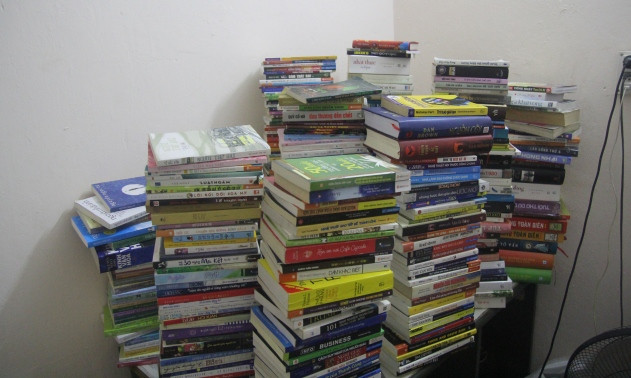 Chồng sách chiếm một góc lớn trong căn phòng trọ nhỏ hẹp của Bình