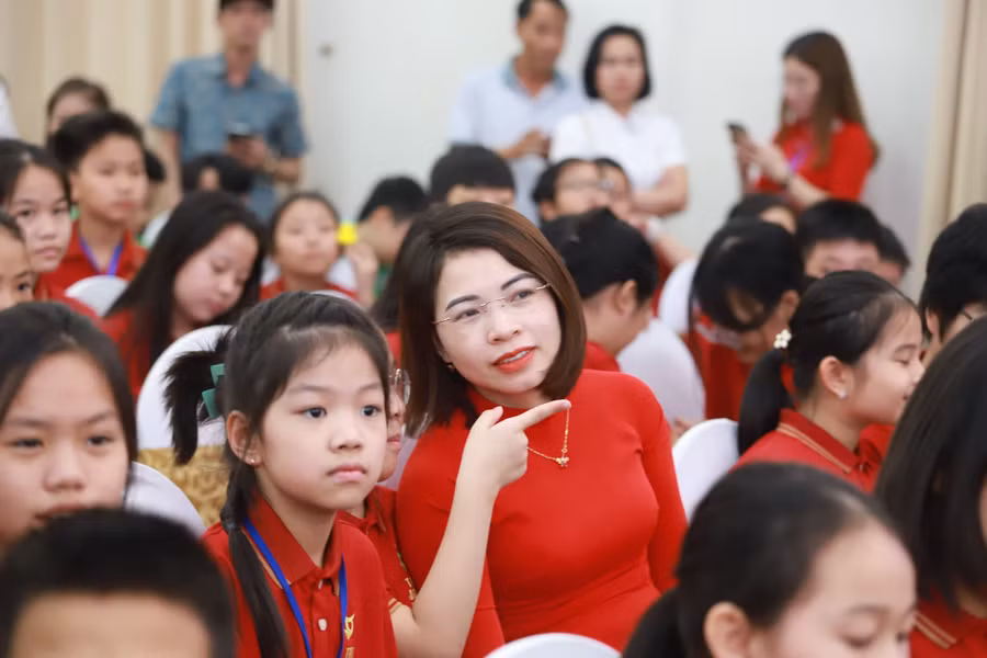 Cô trò cùng chăm chú vào bảng vinh danh trên sân khấu.