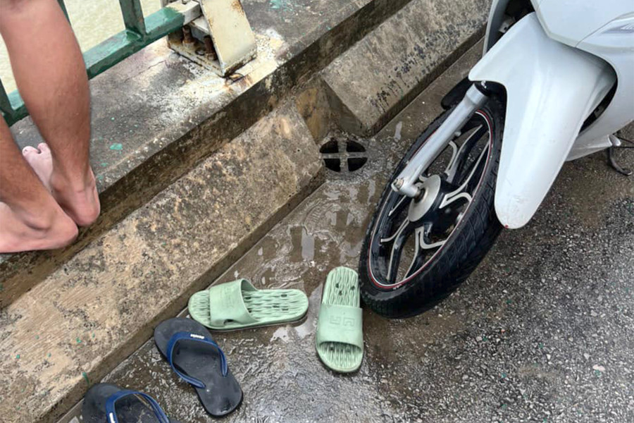 Xe máy và dép của anh T. bỏ lại trên cầu. (Ảnh: CACC)