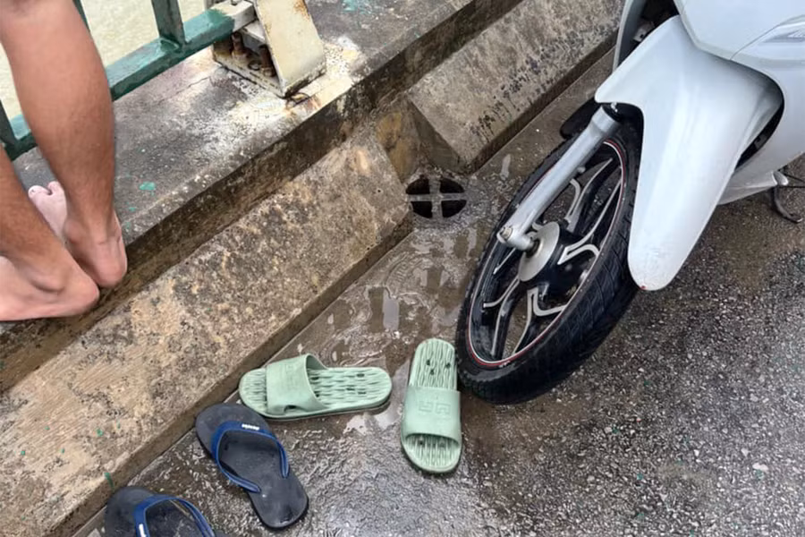 Xe máy và dép của anh T. bỏ lại trên cầu. (Ảnh: CACC)