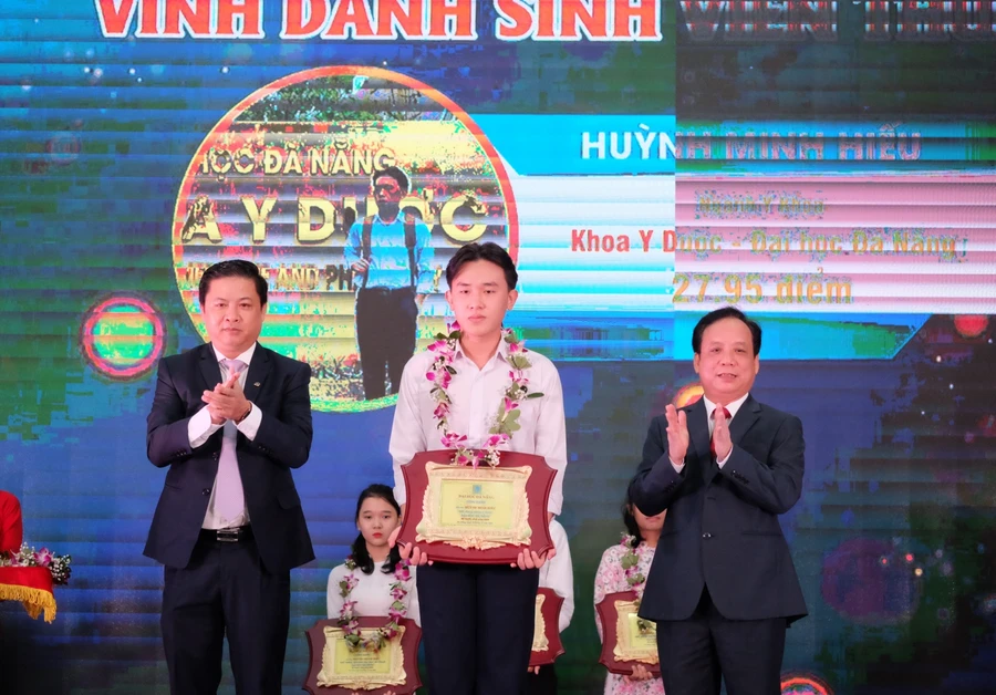 Ông Lương Nguyễn Minh Triết – Phó Bí thư Thường trực Thành ủy Đà Nẵng (bìa trái) và PGS.TS Nguyễn Ngọc Vũ – Giám đốc Đại học Đà Nẵng tặng hoa và bảng vinh danh cho các Thủ khoa Đại học Đà Nẵng năm 2020.  