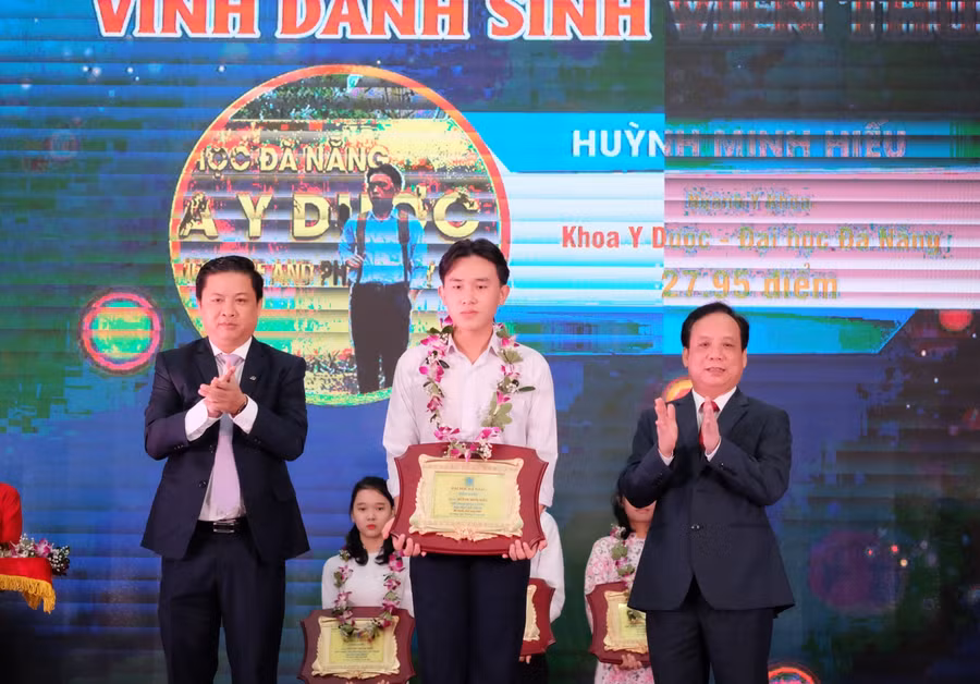 Ông Lương Nguyễn Minh Triết – Phó Bí thư Thường trực Thành ủy Đà Nẵng (bìa trái) và PGS.TS Nguyễn Ngọc Vũ – Giám đốc Đại học Đà Nẵng tặng hoa và bảng vinh danh cho các Thủ khoa Đại học Đà Nẵng năm 2020.  