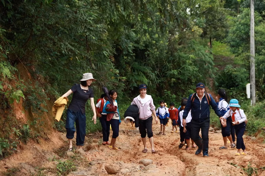 Cô Vân cùng một số giáo viên đi vận động, đưa học sinh đến lớp.