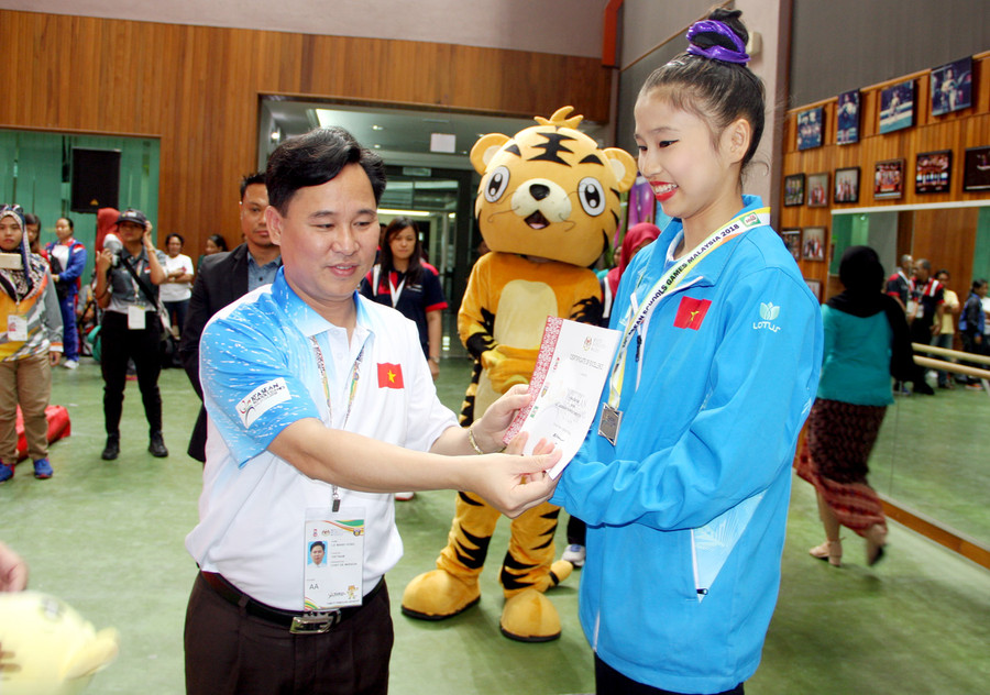 Ông Lê Mạnh Hùng - Phó Vụ trưởng Vụ Giáo dục Thể chất - Trưởng đoàn thể thao học sinh Việt Nam tặng huy chương và giấy chứng nhận cho các vận động viên thể dục giành chuy chương Ông Lê Mạnh Hùng - Phó Vụ trưởng Vụ Giáo dục Thể chất - Trưởng đoàn thể thao học sinh Việt Nam tặng huy chương và giấy chứng nhận cho các vận động viên thể dục giành chuy chương
