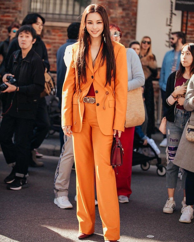 Dù đã gần kề U40 mà cô trông đẹp ngút ngàn với trang phục suit cam cá tính mix cùng giày và túi đỏ thanh lịch đến từ nhà mốt Salvatore Ferragamo