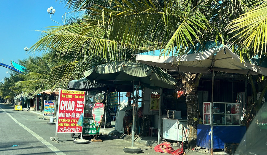 Biển bán hàng, ô dù được bày tràn ra lối đi bộ. (Ảnh: NT). Biển bán hàng, ô dù được bày tràn ra lối đi bộ. (Ảnh: NT).