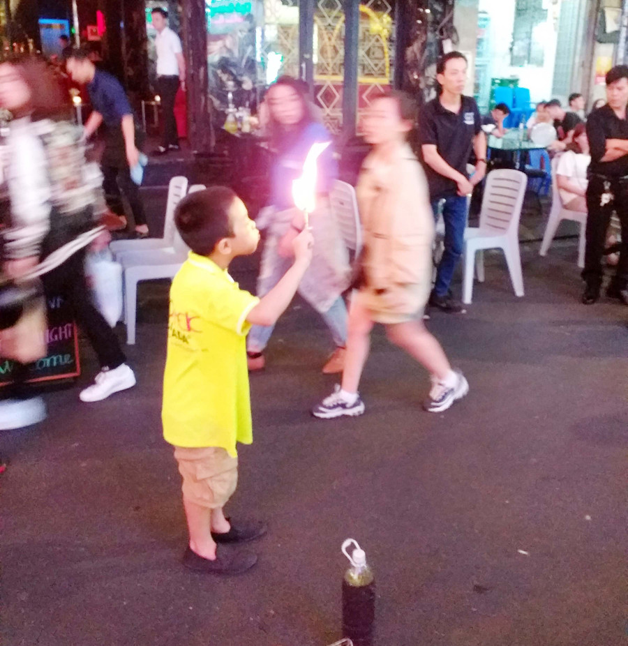 Cậu bé phun lửa mua vui trên phố khiến nhiều người ái ngại