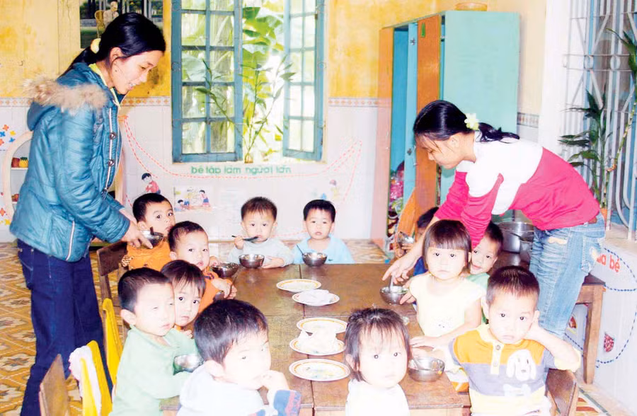 Giáo viên mầm non chăm sóc bữa ăn cho trẻ tại Trường Mầm non Hoa Sen (huyện Cam Lộ, Quảng Trị)