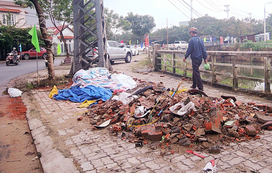 Rác thải xây dựng và xe ô tô để kín vỉa hè khiến người đi bộ phải “lạng lách” (ảnh chụp ngày 17/12/2018)