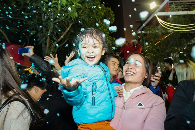 Không chỉ có sinh viên, nhiều gia đình xung quanh khu vực trường cũng dẫn theo con nhỏ đến để ngắm "tuyết trắng" mùa Giáng sinh.