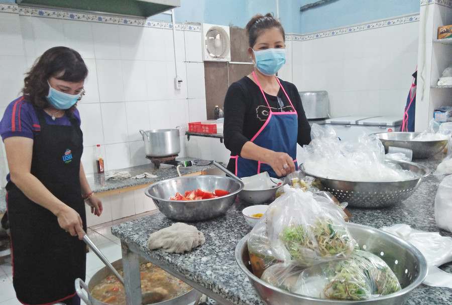 Các tình nguyện viên của bếp ăn đang chuẩn bị các suất ăn trong ngày Các tình nguyện viên của bếp ăn đang chuẩn bị các suất ăn trong ngày