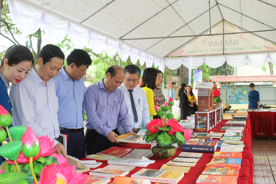 Lãnh đạo Sở Thông tin và Truyền thông (thứ 4 từ trái qua) cùng đại diện Ban Tuyên giáo Huyện ủy Yên Định đọc sách tại quầy trưng bày. Ảnh: LT.