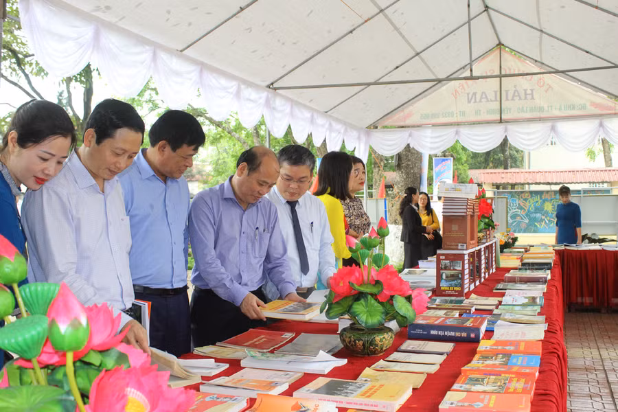 Lãnh đạo Sở Thông tin và Truyền thông (thứ 4 từ trái qua) cùng đại diện Ban Tuyên giáo Huyện ủy Yên Định đọc sách tại quầy trưng bày. Ảnh: LT.