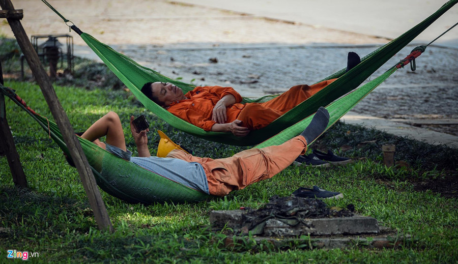 Công nhân điện lực mắc võng nằm nghỉ trưa tại vườn hoa Hàng Đậu (quận Ba Đình). Mat duong o Ha Noi nong hon 50 do C hinh anh 8