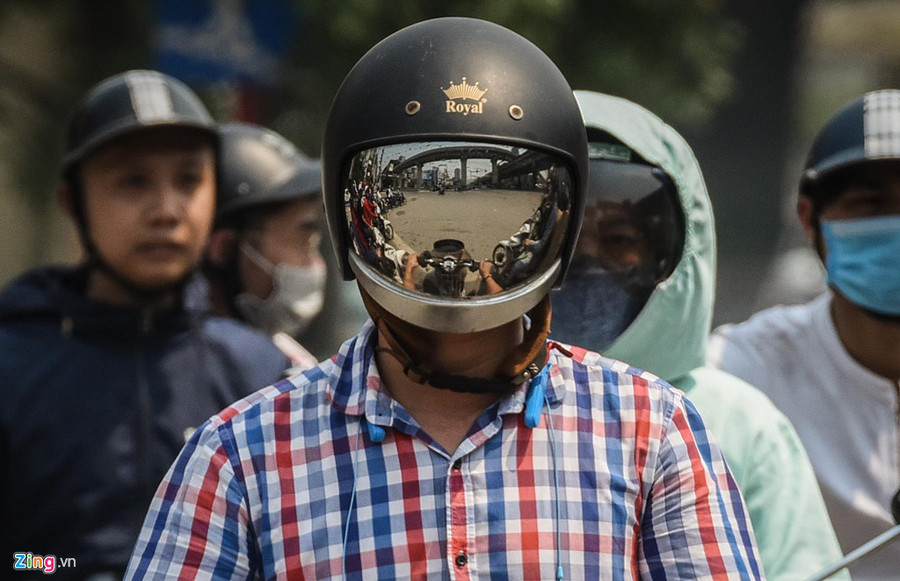 Người dân ra đường sử dụng áo chống nắng, đội mũ bảo hiểm che kín mít mặt lúc giữa trưa trên tuyến đường vành đai 3. Mat duong o Ha Noi nong hon 50 do C hinh anh 5