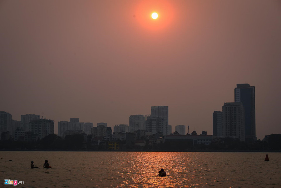 Khoảng 16h, ven hồ Tây trở thành một bãi biển thu nhỏ khi nhiều người đổ về đây tắm giải nhiệt... Mat duong o Ha Noi nong hon 50 do C hinh anh 9