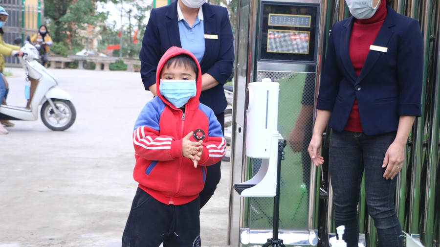 Trẻ tới lớp được cô giáo yêu cầu đo thân nhiệt, sát khuẩn tay trước khi vào lớp.